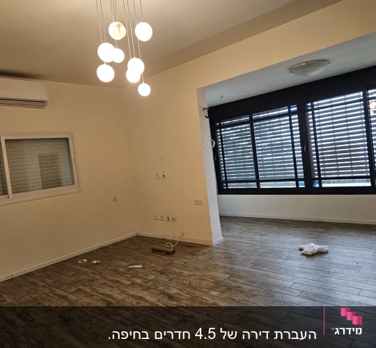 חדר ריק עם רצפת עץ ותאורה תלויה